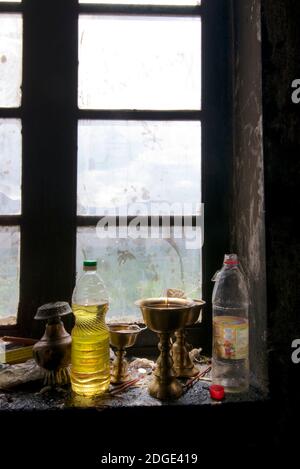 Bougie votive rituelle éclairée et bouteilles d'huile rétroéclairées dans une fenêtre, Palais royal de Shey, Shey, Ladakh, Jammu et Cachemire, Inde Banque D'Images