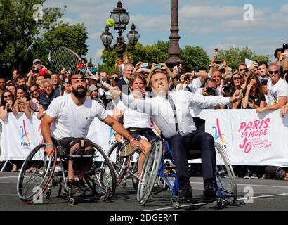 Le président français Emmanuel Macron retourne le ballon en fauteuil roulant alors qu'il joue au tennis sur le pont Alexandre III à Paris, France, le 24 juin 2017. La capitale française est transformée en un parc olympique géant pour célébrer les journées olympiques internationales avec une variété d'événements sportifs pour le public dans toute la ville pendant deux jours, alors que la ville s'offre à accueillir les Jeux olympiques et paralympiques de 2024. Photo de Jean-Paul Pelissier/Pool/ABACAPRESS.COM Banque D'Images