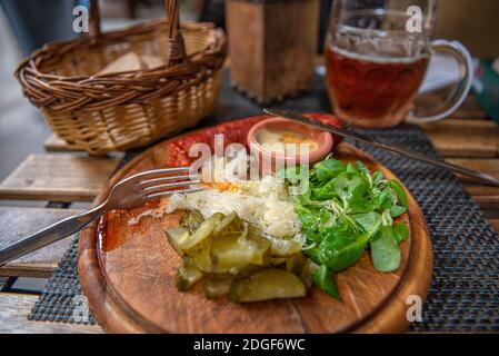 Saucisses grillées sur l'assiette en bois du restaurant Banque D'Images