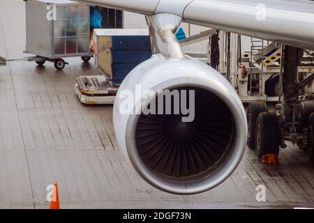 Moteur à jet contre un avion à l'aéroport lors du chargement Banque D'Images