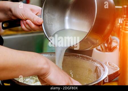 Ajouter de l'eau dans la farine en faisant de la pâte ingrédients frais préparation du repas. Banque D'Images