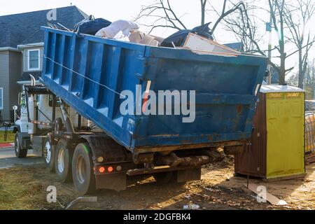 Élimination des débris de construction déchets de démolition de bâtiments avec de la roche et gravats de béton sur les toilettes biologiques portatives Banque D'Images