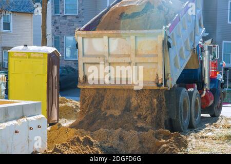 Le camion verse la terre sur le sol dans la zone de construction. Banque D'Images