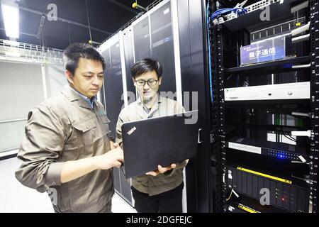 Le personnel vérifie l'équipement de communication quantique dans la salle de communication de Hangzhou, dans la province de Zhejiang, au sud-est de la Chine, le 2 novembre 2020 Banque D'Images