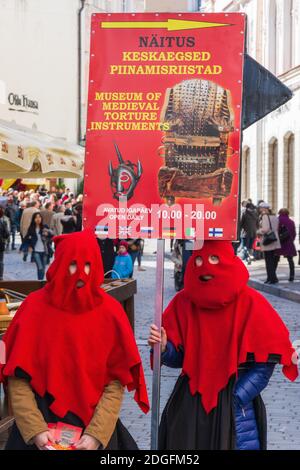 Les instruments médiévaux de torture exposition des annonceurs dans la cagoule rouge sur Viru rue dans la vieille ville de Tallinn Estonie Banque D'Images