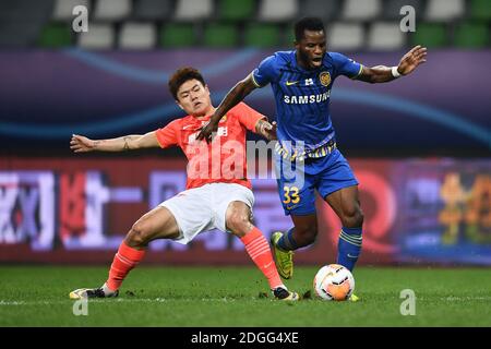 Le joueur de football ghanéen Mubarak Wakaso de Jiangsu Suning F.C., rihgt, protège le ballon pendant le second tour de la finale du Super le chinois 2020 Banque D'Images