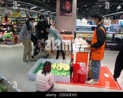 Un supermarché effectue une étrange promotion, tant que les clients achètent une boîte d'oeufs, ils peuvent obtenir deux poulets gratuits, ce qui attire beaucoup d'enfants à Banque D'Images