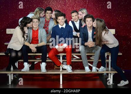 Les fans embrassent les effigies de cire de Naill Horan, Zayn Malik, Louis Tomlinson, Liam Payne et Harry Styles de la bande One Direction à Madame Tussauds à Londres. Banque D'Images