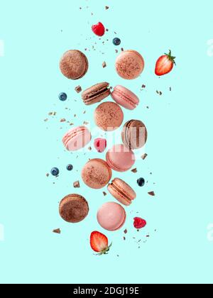 Volez des macarons français sur fond bleu Banque D'Images