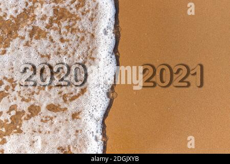 Le mot 2020 2021 est écrit sous forme de texte sur le fond de la plage de sable et de la vague de mousse. Banque D'Images