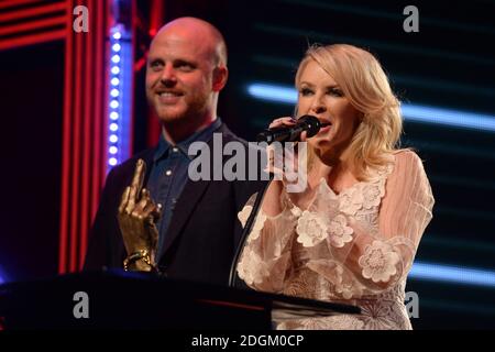 Rédactrice en chef de NME Mike Williams avec Kylie Minogue sur scène alors qu'elle présente le Golike Genius Award à Coldplay pendant les NME Awards 2016 avec Austin, Texas à l'O2 Brixton Academy, Londres. Banque D'Images