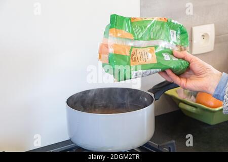 Primelin – France, 22 janvier 2020 : mettre les pâtes Fiorini dans l'eau bouillante de la casserole Banque D'Images