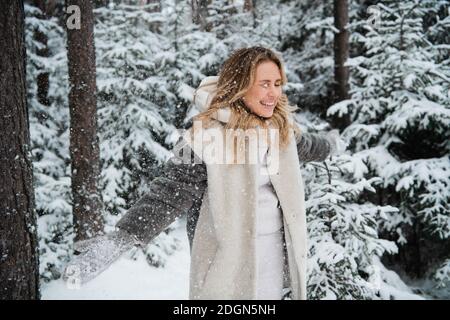 Belles promenades blondes dans le parc en hiver, la neige est partout. Banque D'Images