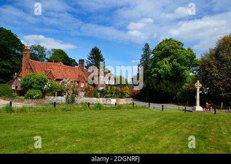 Vue sur les chalets et un mémorial de guerre celtique, sur le vert du village à Lee Common, Buckinghamshire, Royaume-Uni Banque D'Images