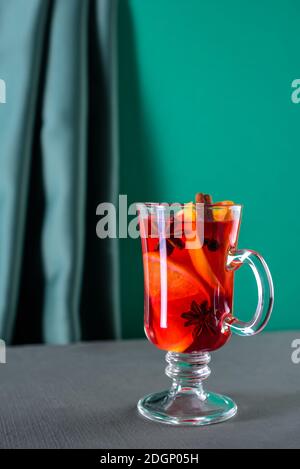Verre de vin chaud sur fond vert et tissu Banque D'Images