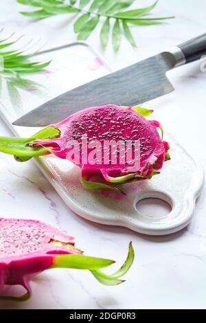 Fruit de dragon rose, pitaya ou pitahaya coupé en cubes. Super-nourriture tendance sur planche à découper blanche. Banque D'Images