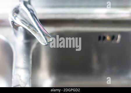 Vue de dessus du levier mélangeur d'un robinet en cascade chromé d'une cuisine domestique avec l'évier en aluminium en arrière-plan. Calcaire sur le levier Banque D'Images