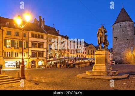 Scène nocturne sur la place Pestalozzi à Yverdon les bains, Suisse avec sa statue, une rangée de maisons historiques et le château d'Yverdon. Banque D'Images