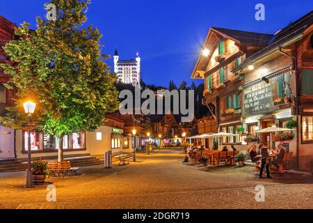 Scène nocturne le long de la charmante promenade de Gstaad, une station de montagne populaire dans le canton de Berne en Suisse. Couronnant la ville, le fabuleux Banque D'Images