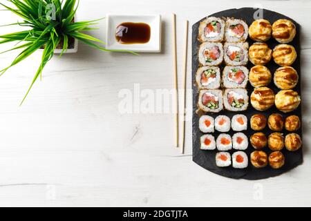 Des petits pains à sushis sont mis en place sur un plateau en pierre pour les sushis un arrière-plan clair Banque D'Images