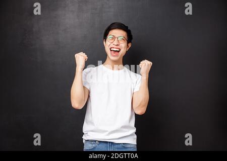 Guy qui s'est employé à l'équipe pour regarder un match de sport au pub. Joyeux fan de sport asiatique, célébrant la victoire, l'équipe a marqué le but Banque D'Images