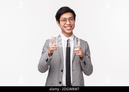 Portrait à la taille d'un jeune homme d'affaires asiatique en costume, bon et réussi, à la recherche de nouveaux employés, montrant fi Banque D'Images