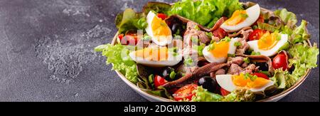 Salade française niçoise au thon, œufs, haricots verts, tomates, olives, laitue et anchois. Banque D'Images