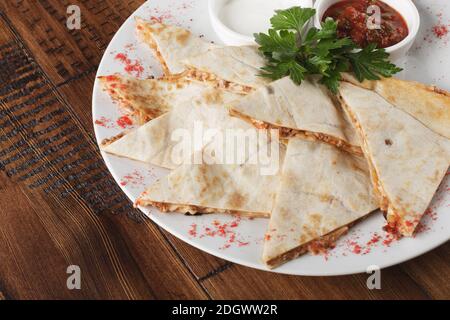 quesadilla avec bœuf et poulet sur une table en bois brun. vue du dessus. quesadilla et sauce. Banque D'Images