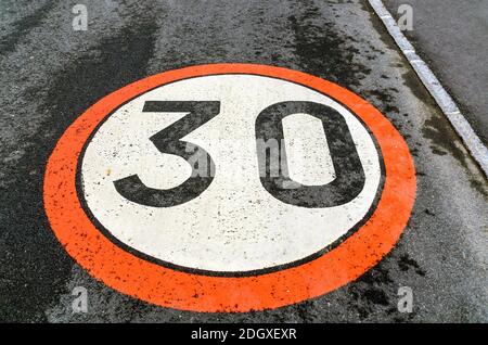 signalisation routière d'une limite de vitesse de 30 km/h, peinte sur une chaussée asphaltée Banque D'Images