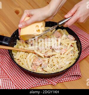 Pâtes fraîches préparées avec saumon et sauce à la crème dans une casserole Banque D'Images