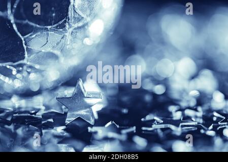 Photo macro de l'étoile argentée brillante et de la sphère de verre fissurée Banque D'Images