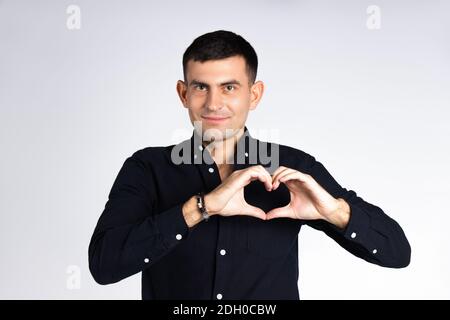 Un homme tient un coeur de ses mains sur un fond blanc. Concept de don, de charité et de Saint-Valentin. Banque D'Images