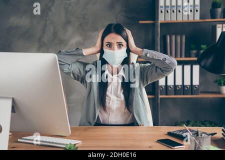 Photo de la fille choquée inquiet agent de masque médical représentant s'asseoir table de bureau entendre le patron de nouvelles horrible compagnie de faillite elle le fera perdre le toucher d'urgence du travail Banque D'Images