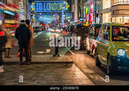 LONDRES, Royaume-Uni - 08 DÉCEMBRE 2020 - cette rue Oxford Street de Noël est éclairée par 27 rideaux de lumière LED drapés sur la longueur de la rue avec projection o Banque D'Images