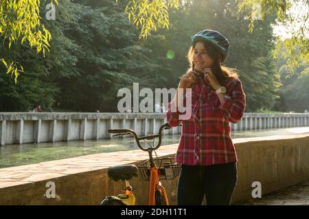 Sujet mode écologique de transport vélo. Belle jeune femme caucasienne portant un casque bleu et de longs cheveux poses debout Banque D'Images