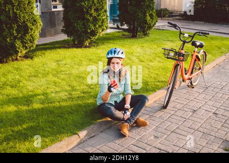 Sujet mode écologique de transport vélo. Belle jeune femme caucasienne portant un casque bleu et de longs cheveux poses debout Banque D'Images