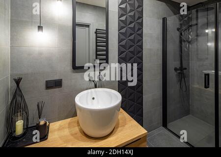 Intérieur moderne de la salle de bains dans l'appartement de luxe. Évier à bols blanc. Robinet noir. Miroir sur mur. Cabine de douche en verre. Banque D'Images