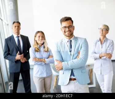 Groupe d'hommes d'affaires debout au bureau avec leur jeune leader de bussines Banque D'Images
