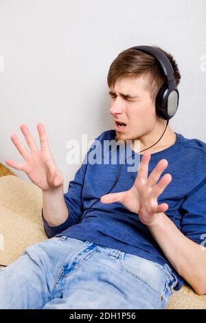 Joyeux jeune homme dans le casque écouter la musique Par le mur Banque D'Images