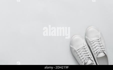 Baskets blanches sur fond bleu, espace pour les copies, vue du dessus Banque D'Images
