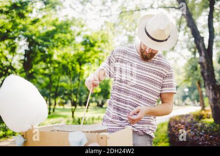 Photo thème petits affaires de cuisine bonbons. Un jeune homme avec une barbe d'un commerçant caucasien dans le chapeau le propriétaire de la sortie mak Banque D'Images