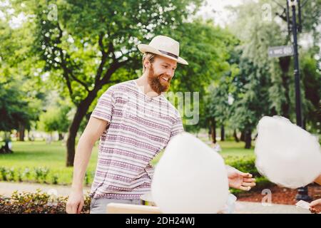 Photo thème petits affaires de cuisine bonbons. Un jeune homme avec une barbe d'un commerçant caucasien dans le chapeau le propriétaire de la sortie mak Banque D'Images