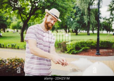 Photo thème petits affaires de cuisine bonbons. Un jeune homme avec une barbe d'un commerçant caucasien dans le chapeau le propriétaire de la sortie mak Banque D'Images