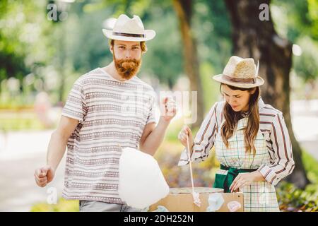 Le thème est une famille petite entreprise de cuisine des bonbons. Une paire d'amants UN jeune homme et une femme commerçant dans le chapeau le propriétaire de l'outle Banque D'Images