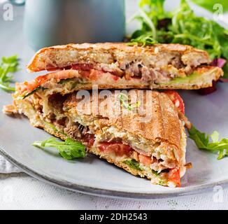 Panini au club grillé avec du bœuf, de la tomate, du fromage, de la laitue et une tasse de café. Délicieux petit déjeuner ou en-cas. Banque D'Images