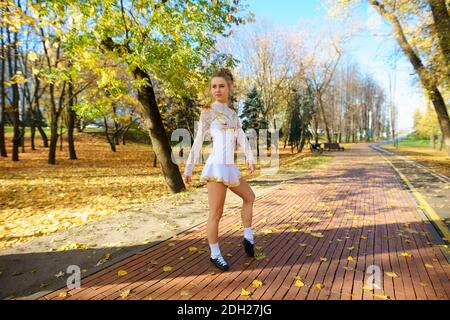 Ballerine dansant dans le parc naturel parmi les feuilles d'automne. Banque D'Images