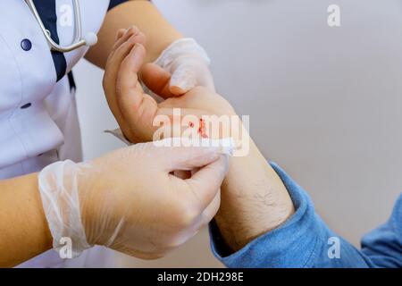 Services médicaux de lingettes bandages médecin sur la main blessée Banque D'Images