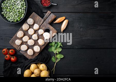 Spécialités de la mer, pétoncles à la pomme de terre, pois verts et menthe, vue de dessus, sur fond en bois noir avec espace pour les copies Banque D'Images