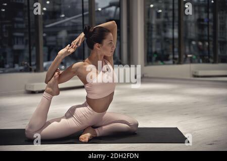 Belle fille d'entraînement dans la salle de gym. Danseuse russe classique qui se stretching et pose de yoga Banque D'Images