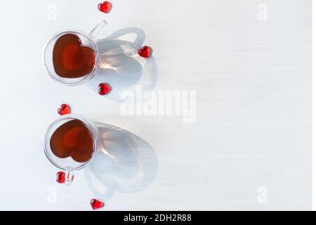 Deux tasses à thé en forme de coeur avec coeurs rouges sur table en bois blanc vue sur le dessus. Concept de la Saint-Valentin. Dîner romantique de la Saint-Valentin. Banque D'Images